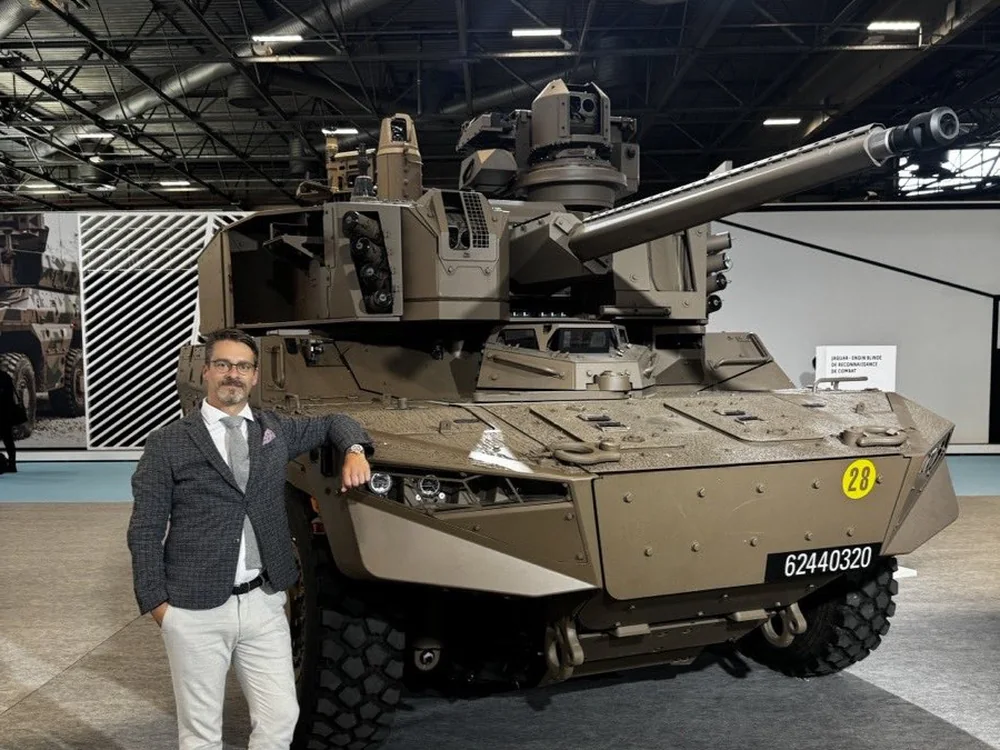 David Ertler as a reconnaissance officer at the French Army stand in front of a wheeled reconnaissance vehicle